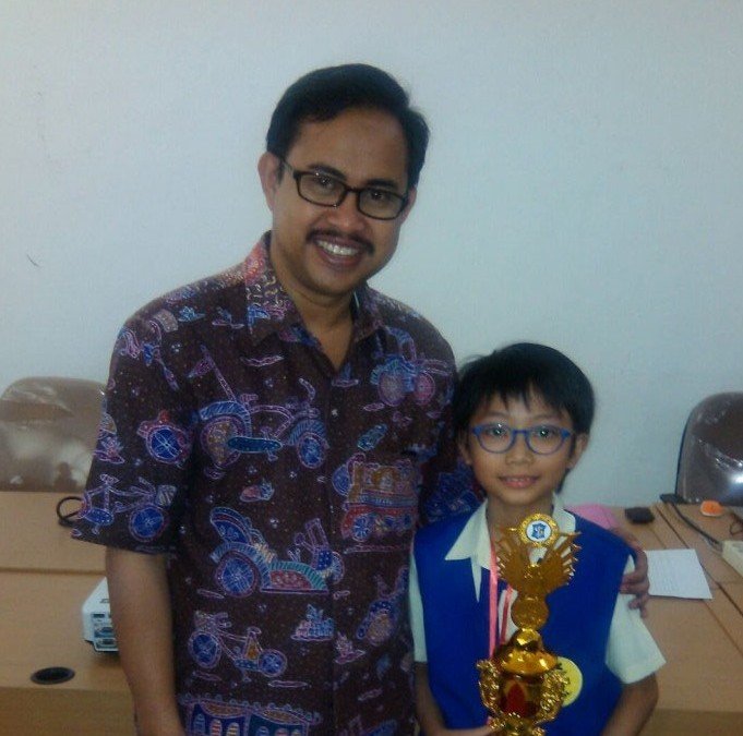 Kadispendik Surabaya Dr. Ikhsan, S.Psi, MM handed the  Student Achievement Champion Trophy To Michael Wahayu From SD JAC.